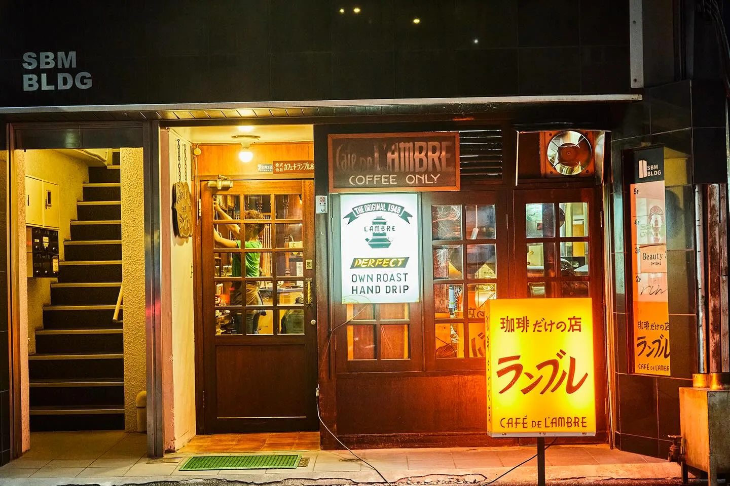 Photo by カフェ・ド・ランブル on June 01, 2026. May be an image of signboard, street, buildings and text that says 'BLDG 제소로나품 ※カフェドランブルボ MIlBRt MaD COFFEE COFFEEONLY ONLY SMAL1949 O MEOSIGNAL19 1948 LAMBRE 8M BLOG LOG d PERFECT OWN ROAST HAND DRIP Beauty 北琲 だけの店 ランブル CAFE: CAFEHLFTER LfTER 珈琲だけの店 ランブル CAFÉ DE CAFÉDEL'AMBRE L'AMBRE'.