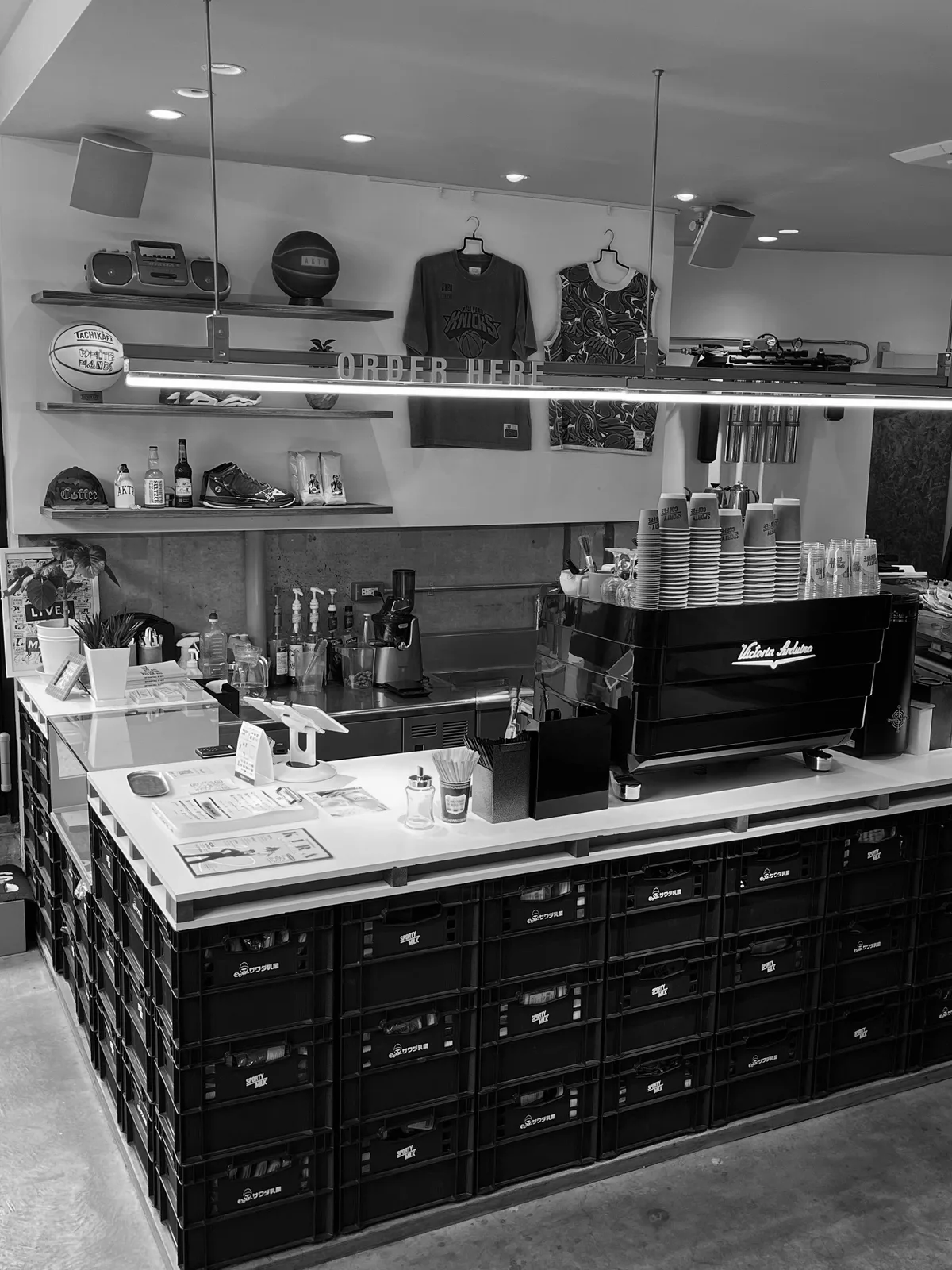 Photo shared by AKTR Sports Supply on August 06, 2026 tagging @sporty_coffee. May be a black-and-white image of rack, display case, hat shop and text.